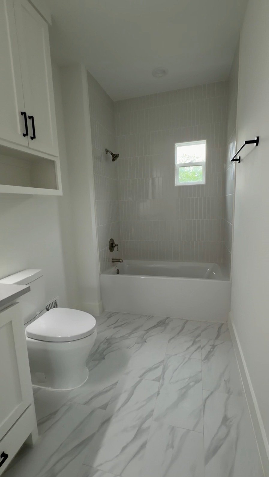Remodeled bathroom with tiled tub surround