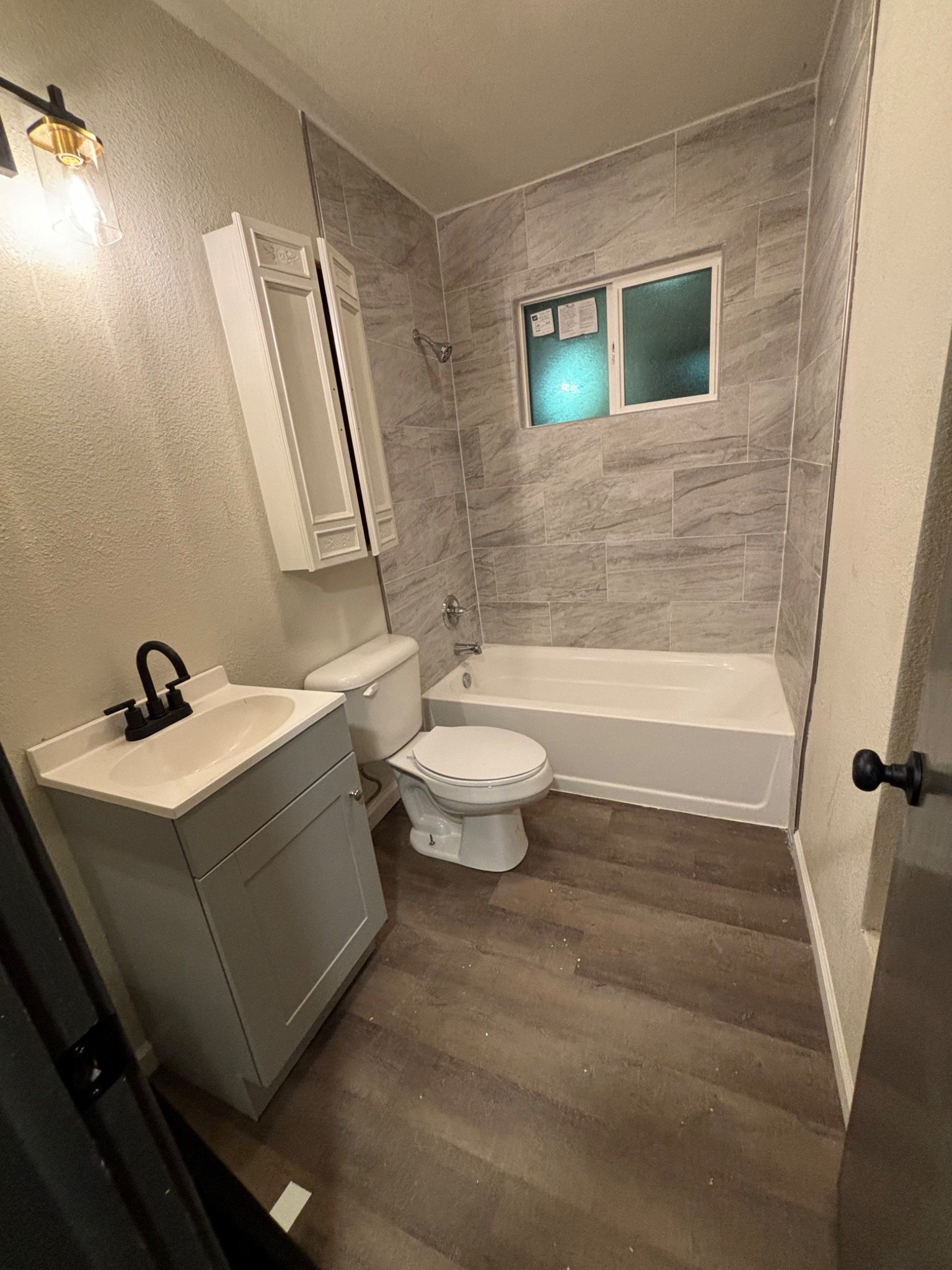 Bathroom renovation with gray tile and vanity