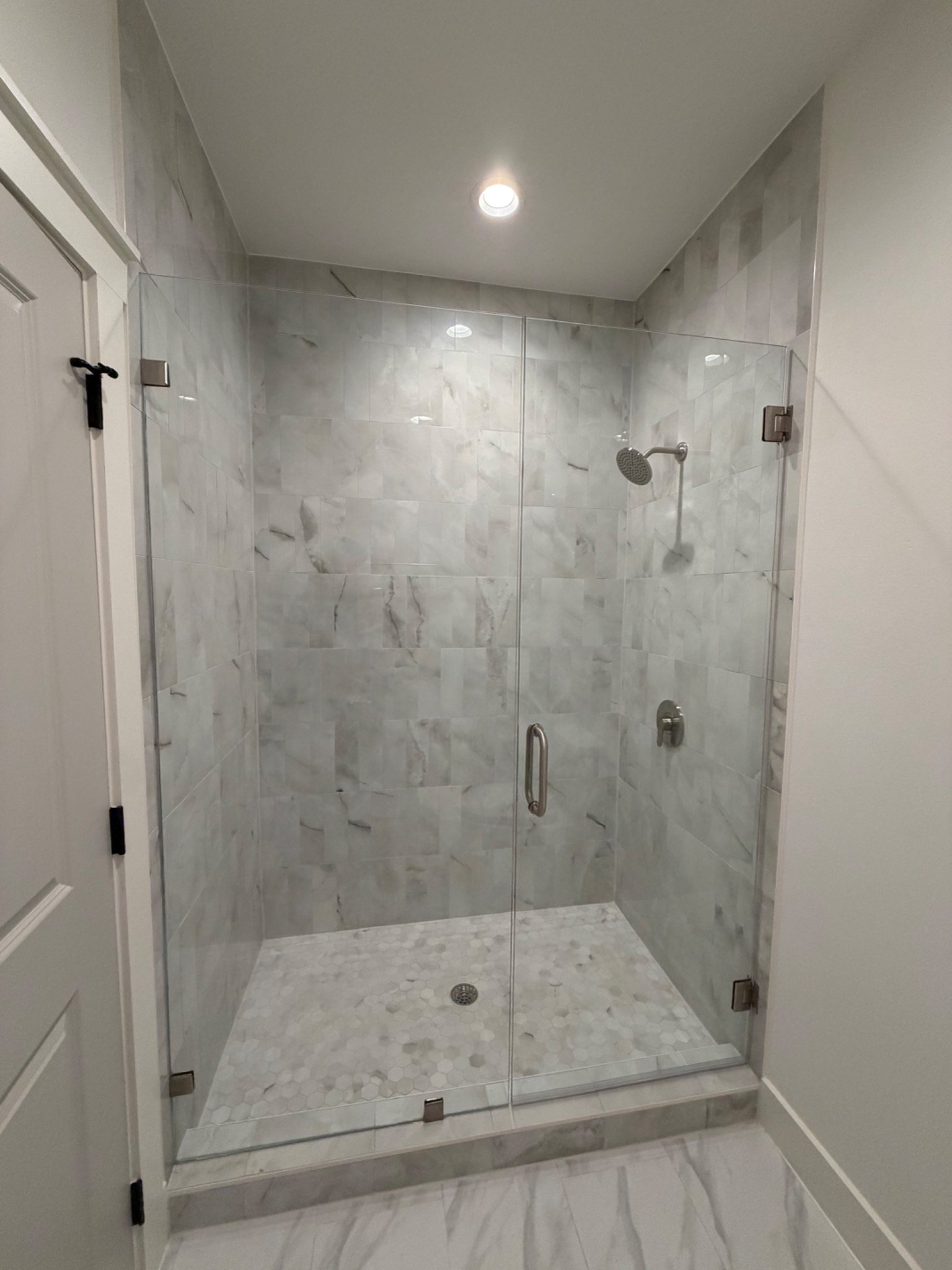Custom tiled walk-in shower with frameless glass